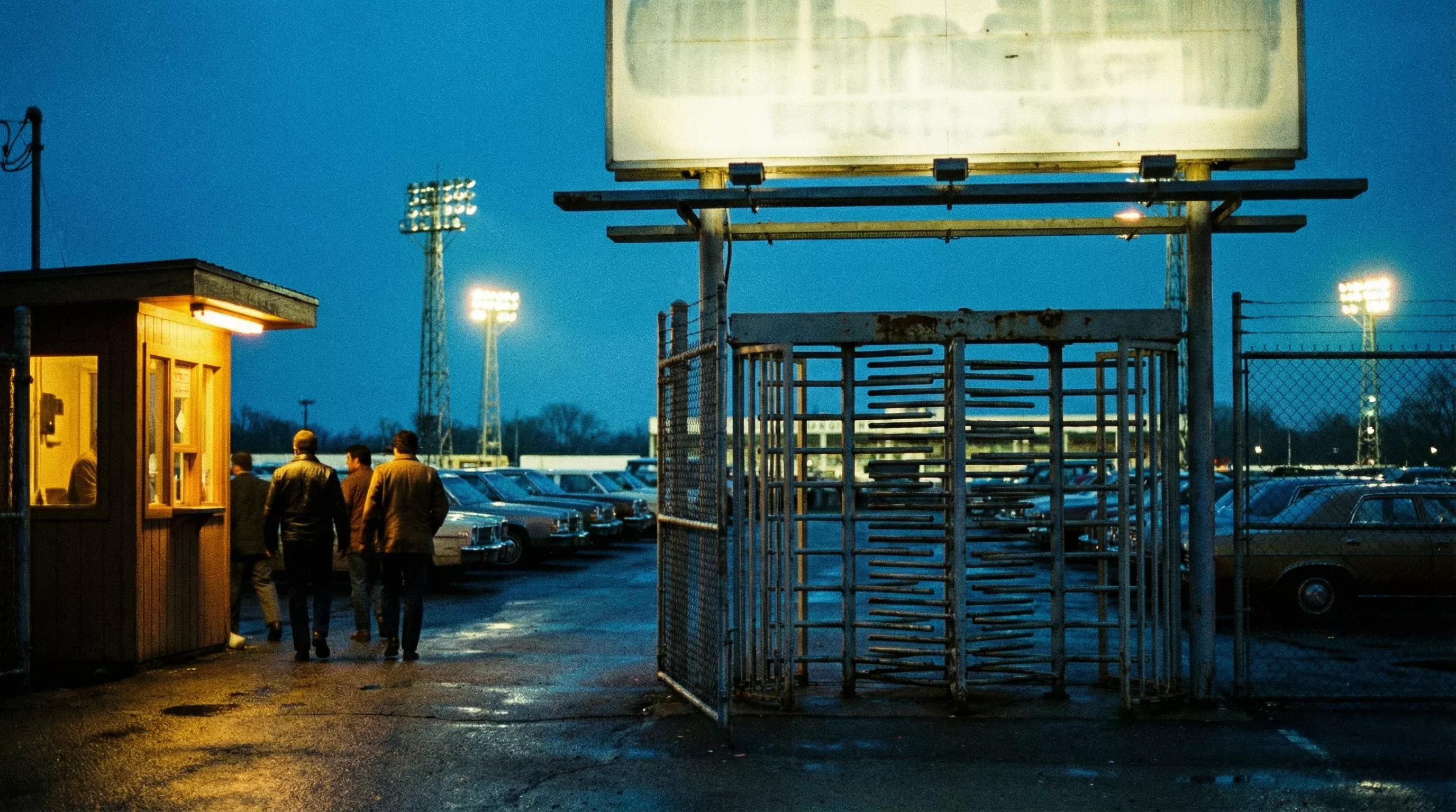 Entrance gate of Sunderland Greyhound Stadium with an illuminated sign and turnstile in the evening
